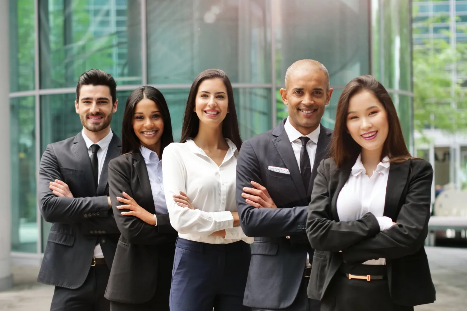 Group of professionals standing outside a modern building, symbolizing teamwork and corporate culture.